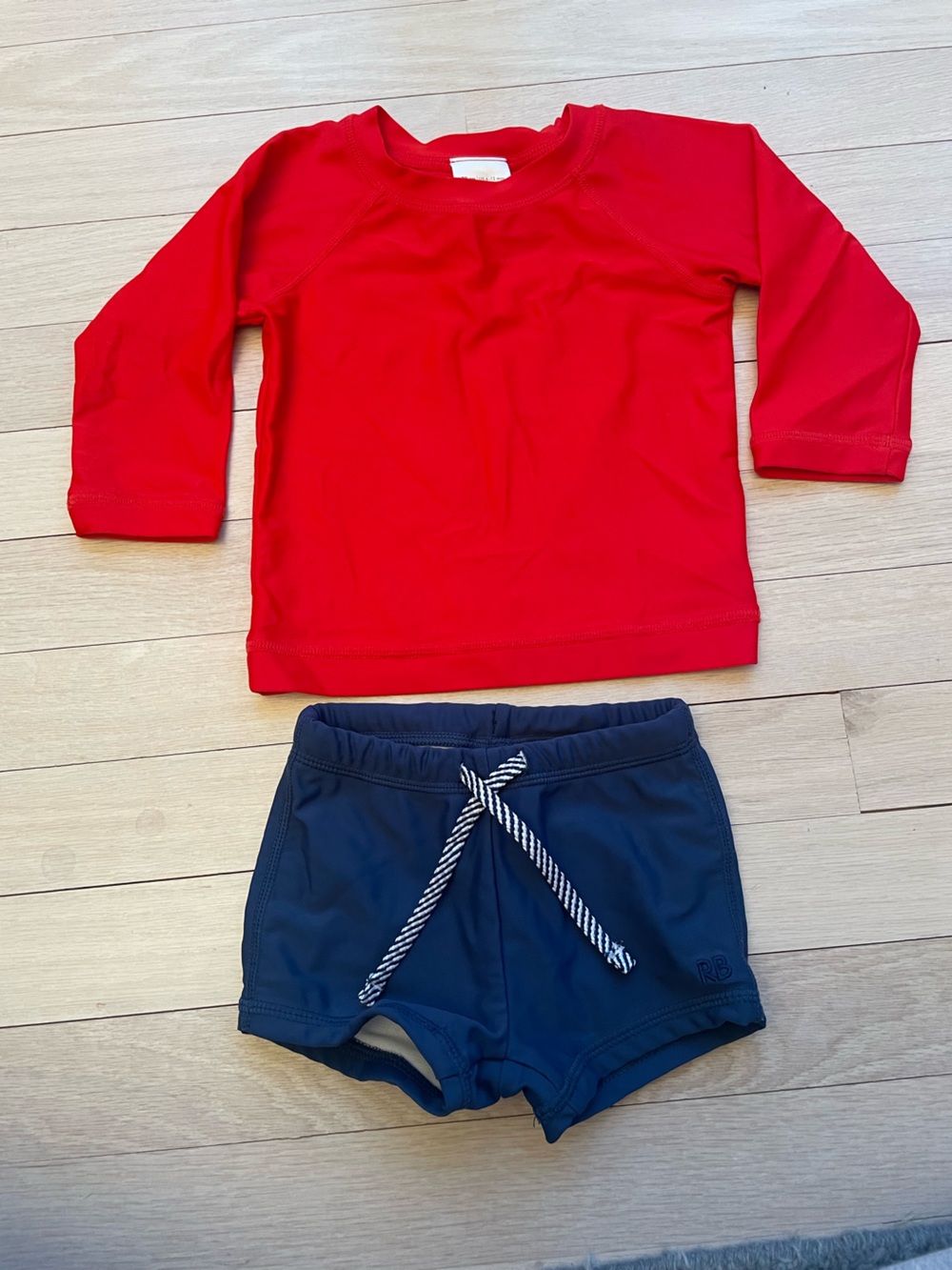 Ruggedbutts navy swim shorts with Hanna Andersson red rash guard